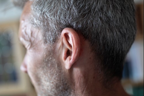 På billedet ses en mands øre.